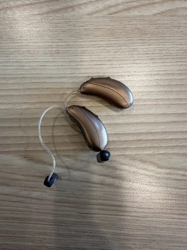 pair of used unitron hearing aids in bronze