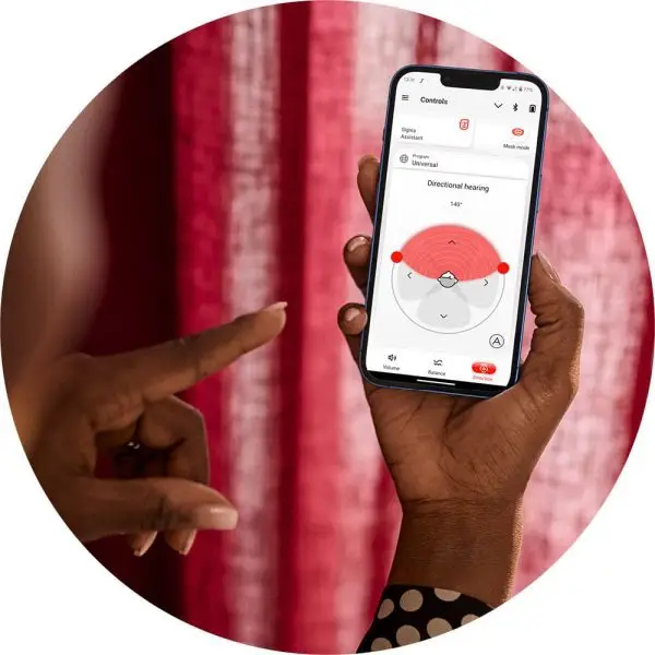 woman holding phone using signia app with signia hearing aids