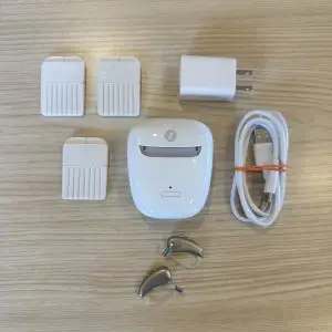 used signia 7ix t hearing aids with portable cahrger, wax guards, cable, and wall plug